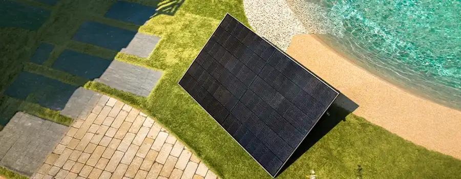 Panneau solaire Plug and Play monocristallin posé au sol sur support inclinable dans un jardin résidentiel près d'une piscine, illustrant une installation solaire simple et autonome en Belgique